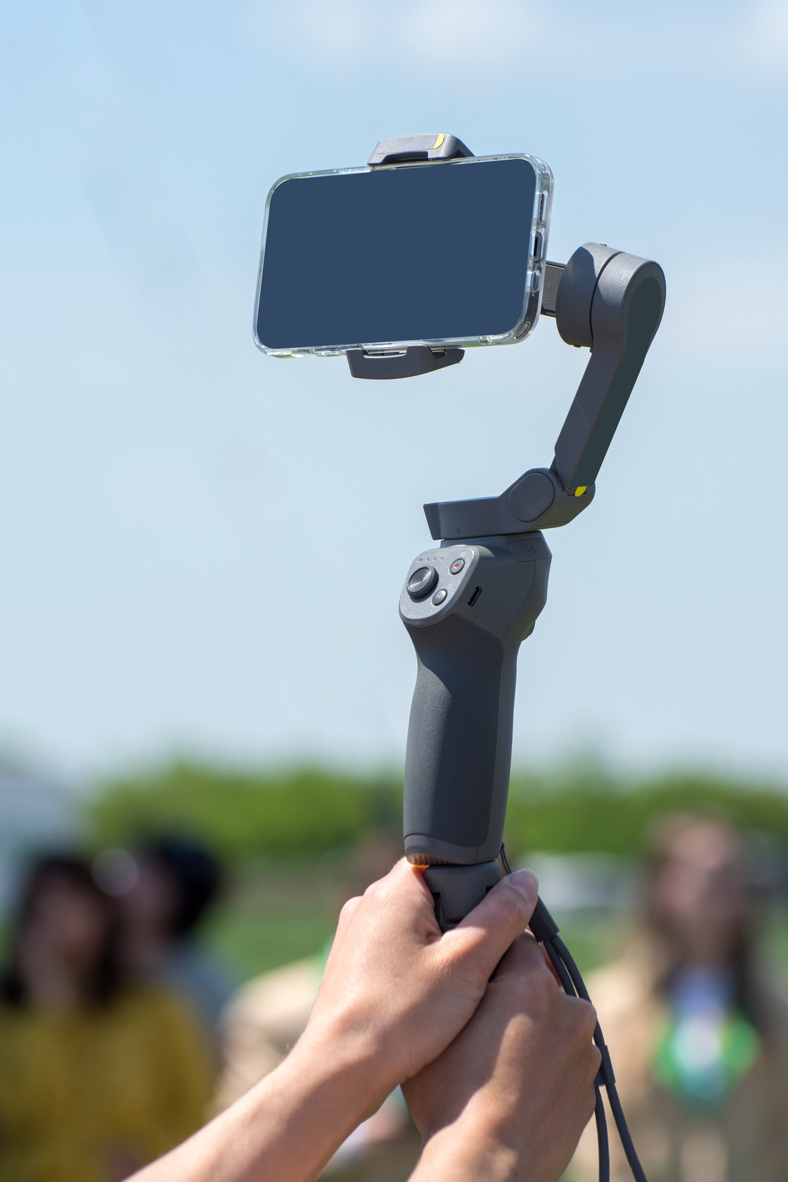 Handheld smartphone stabilizer in the hands of a blogger